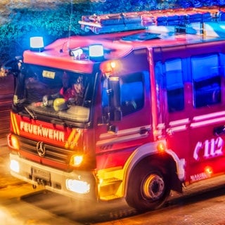 Ein Feuerwehr Fahrzeug fährt durch die Nacht.