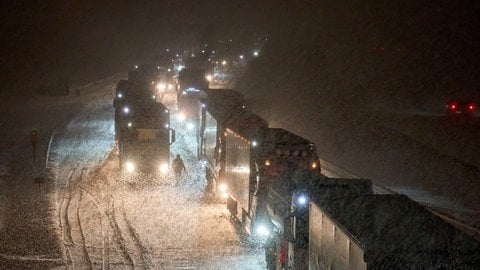 Auf der A3 im Westerwald stehen bei Schnee viele Lkw im Stau.