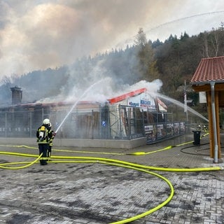 Feuerwehrleute löschen in Adenau das Feuer auf dem Gelände eines Baustoffhandels