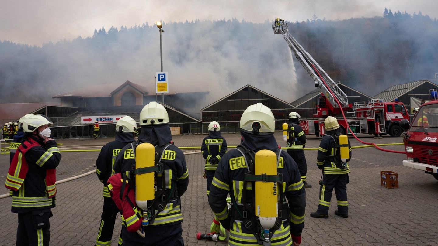 Feuerwehrleute in voller Ausrüstung haben den Großbrand eines Baumarkts in Adenau gelöscht.