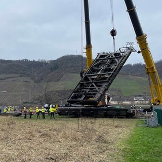 Die zerstörten Tore werden von einem Kran aus der Mosel-Schleuse Müden gehoben.