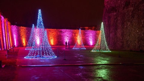 Besucher gehen durch die Lichtinstallationen des weihnachtlichen Lichtevents Christmas Garden auf der Festung Ehrenbreitstein in Koblenz. Das weihnachtliche Event kann bis zum 08. Januar 2025 besucht werden.