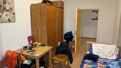 Zimmer mit Bett, Stuhl und Tisch, Kleiderschrank