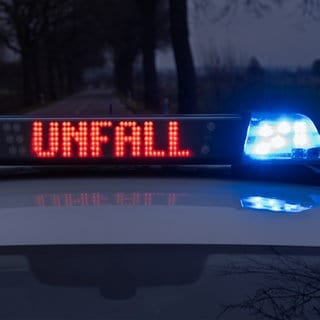 Ein Streifenwagen der Polizei steht bei einem Verkehrsunfall mit Blaulicht und dem Schriftzug "Unfall" im Display auf einer Landstraße. Im Kreis Altenkirchen hat ein Autodieb bei einer Spritztour mit einem gestohlenen Auto einen Unfall mit Totalschaden verursacht. 