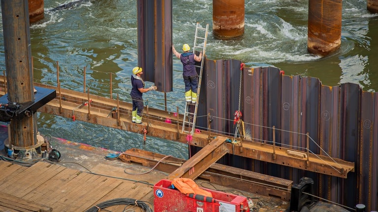 Im Rhein selbst sind die Arbeiten während des Jahres 2024 für den Brückenneubau weiter vorangeschritten, wie hier im Mai beim Bau eines Spundwandkastens. 