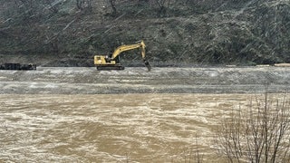 Bagger steht im Hochwasser der Ahr bei Marienthal