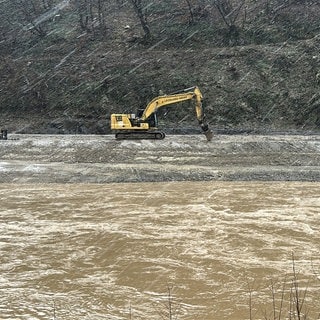 Bagger steht im Hochwasser der Ahr bei Marienthal