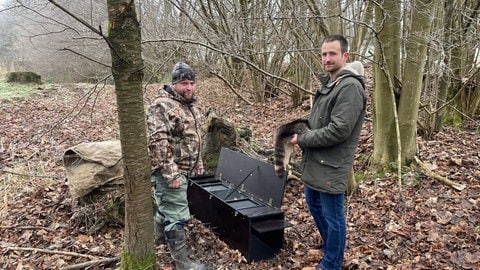 Benedikt Börgerding und Christian Heidtmann an der Waschbärfalle.