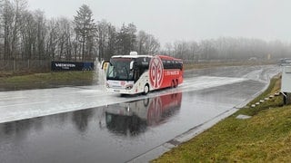 Mannschaftsbus von Mainz 05 auf dem Nürburgring. Der Busfahrer des Vereins trainiert dort das Fahren bei schlechtem Wetter.