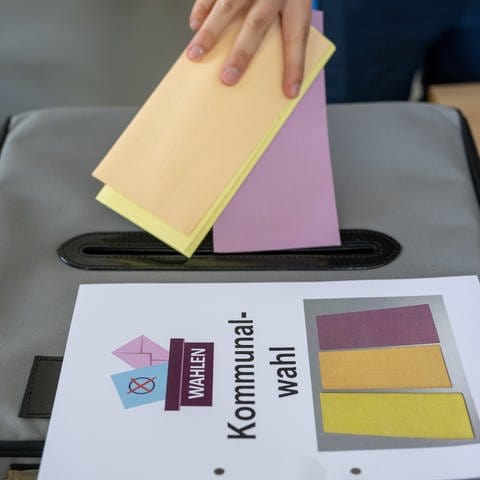 Ein Wähler wirft seine Stimmzettel in die Wahlurne für die Kommunalwahl in Rheinland-Pfalz 2024