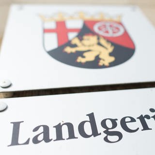 Ein Schild mit dem rheinland-pfälzischen Landeswappen und der Aufschrift "Landgericht" in Landau