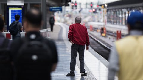 Menschen stehen an einem leeren Bahngleis und warten auf einen Zug. (Foto: picture-alliance / Reportdienste, picture alliance / dpa Themendienst | Frank Rumpenhorst)