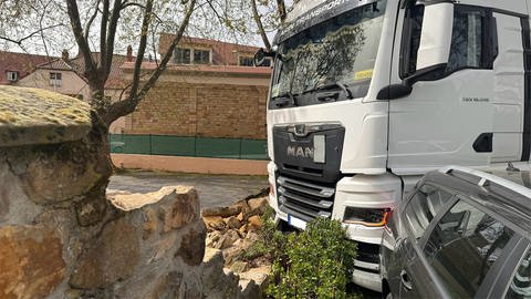 Lastwagen steht in einer kaputten Mauer