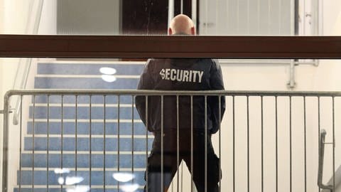 Ein Mitarbeiter eines Sicherheitsdiensts bewacht ein Gebäude (Symbolbild)