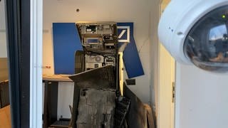 Ein zerstörter Raum mit einem kaputten Geldautomat.