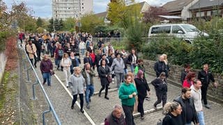 Menschen gedenken in Ludwigshafen-Oggersheim an die Opfer der Messerattacke.