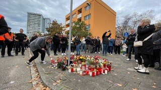 Menschen gedenken in Ludwigshafen-Oggersheim an die Opfer der Messerattacke.