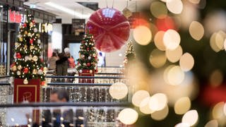 Berlin: Kunden gehen durch ein weihnachtlich geschmücktes Einkaufszentrum in Mitte. 