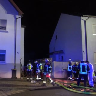 Feuerwehrleute löschen einen Brand in einem Mehrfamilienhaus in Ludwigshafen.