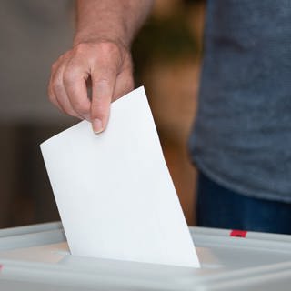 Ein Wähler wirft in einem Wahllokal seinen Stimmzettel in die Wahlurne.