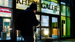 Stromausfall in Ludwigshafen: Ein Mann steht vor der schwach beleuchteten Rheingalerie