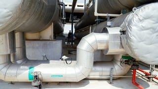 Rohre mit Thermalwasser führen zu Behältern eines Wärmetauschers an einer Lithium-Pilotanlage der Natürlich Insheim GmbH.