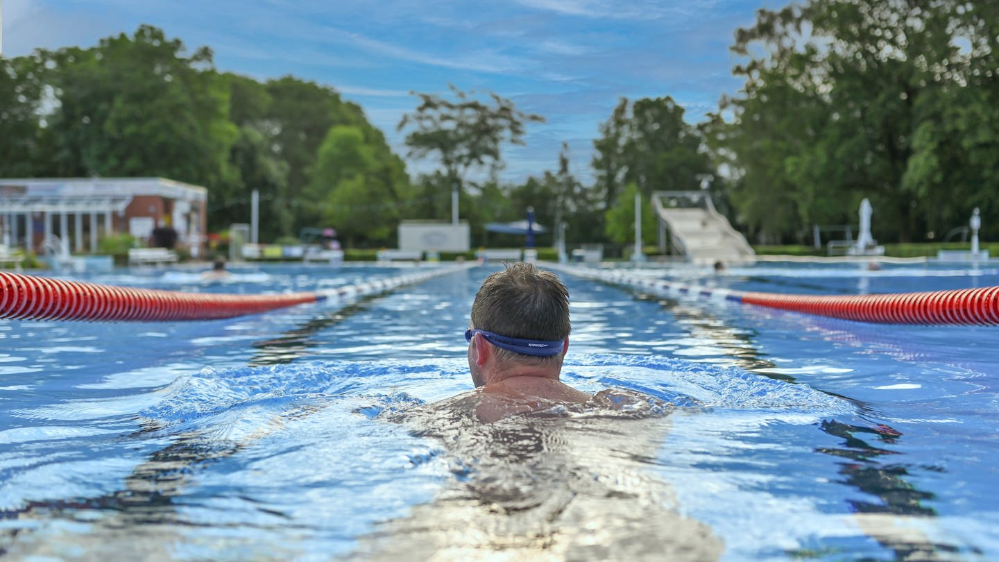 Ein Badegast genießt das Schwimmen im Freibad