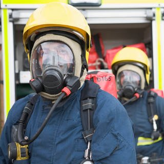 Zwei Feuerwehrmänner mit Atemschutzgerätz - Symbolbild für Mehrfamilienhaus in Landau nach Kohlenmonoxidalarm geräumt