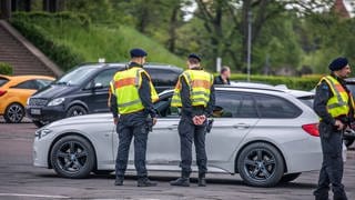 Polizisten ziehen ein Auto aus dem Verkehr.