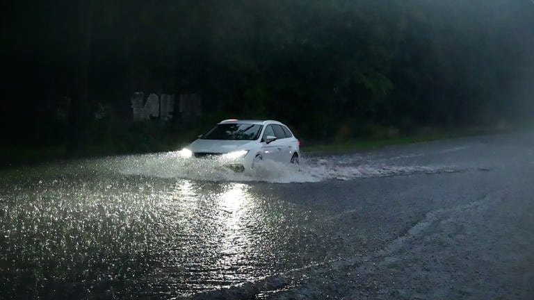 Unwetter droht: Auto fährt über überflutete Straße