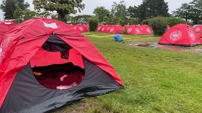 Dänische Fans im Aufbruch und die Zelte des Camps in Bad Dürkheim werden an das Deutsche Rote Kreuz gespendet.