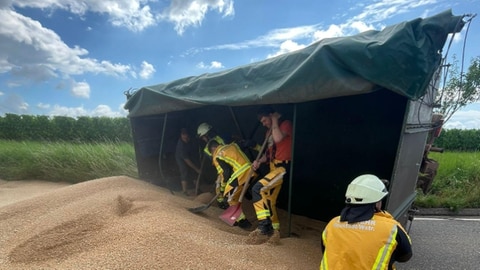 Die Feuerwehr in Neustadt muss Getreide von der Straße räumen