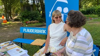 Gemeindeschwester-Plus Heidi Gangkofner (links) auf ihrer Plauderbank auf dem Friedhof Speyer.