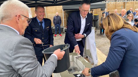 Innenminister Michael Ebling (SPD) mauert gemeinsam mit Oberbürgermeisterin Jutta Steinruck (parteilos) die Zeitkapsel in den Grundstein des neuen Polizeipräsisiums in Ludwigshafen ein