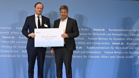 Bundeswirtschaftsminister Robert Habeck (Grüne) übergibt die Zusage für 310 Millionen Euro Fördergelder an Uwe Liebelt, Präsident Europäpische Verbundsstandorte der BASF.