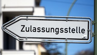 Ein Schild das zur Zulassungsstelle weist