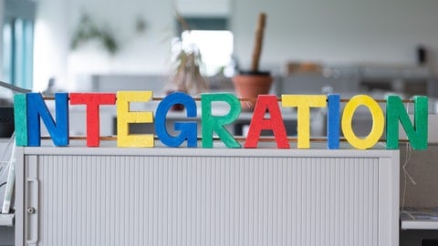 Bunte Buchstaben aus Styropor auf einem Schrank in einem Büro formulieren das Wort "Integration"