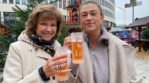 Der Weihnachtsmarkt Ludwigshafen. Erste Besucher wärmen sich von innen.