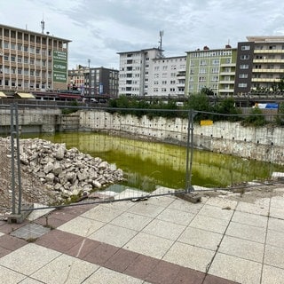 Das Bauloch am Berliner Platz in Ludwigshafen wird allmählich zum Feuchtbiotop. Der Stadtrat hat darüber diskutiert, auf dem Areal ein neues Büro- und Geschäftshaus zu errichten, in das auch die Ludwigshafener Stadtverwaltung einziehen soll.