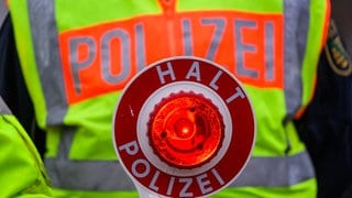 Eine Polizeikelle während einer Verkehrskontrolle. Autofahrer nehmen verbotene Abkürzungen für die gesperrte B9.