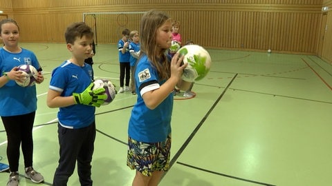 Training der TSG Deidesheim: Drei Kinder halten einen Ball in der Hand. Das Inklusionstraining bei der TSG Deidesheim trainiert die motorischen Fähigkeiten der Kinder.