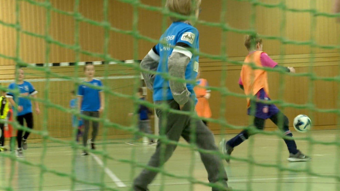 Kinder der TSG Deidesheim beim Hallenfußball durch das Netz eines Fußballtores betrachtet.