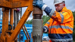 Ein Arbeiter mit einem Bohrgestänge auf einer Geothermie-Anlage