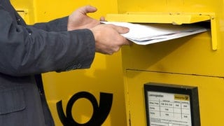 Briefe werden in Briefkasten der Post eingeworfen. In der Südpfalz soll eine Bande Rechnungen aus Postbriefkästen geklaut und manipuliert haben.