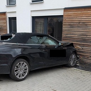 Ein beschädigter Audi vor einer eingedrückten Hauswand: Eine Frau in Edenkoben ist beim Parken mit ihrem Auto versehentlich gegen die Hauswand gefahren.