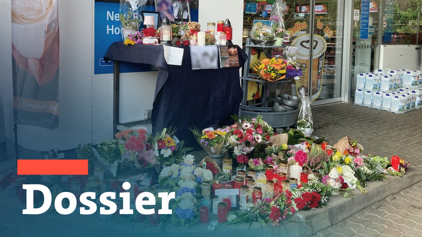 Blumen und Kerzen sind vor einer Tankstelle aufgestellt. Ein Angestellter der Tankstelle war am Samstagabend von einem mit einer Pistole bewaffneten Mann erschossen worden.