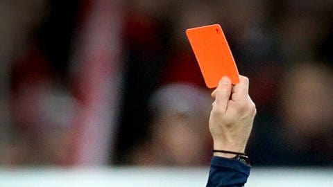 Ein Schiedsrichter zeigt die Rote Karte.
