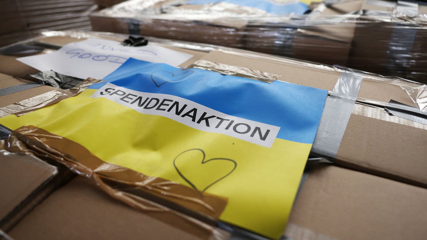 Ein Schild mit der Aufschrift Spendenaktion ist auf einem Karton mit Hilfsgütern für die Ukraine aufgeklebt.