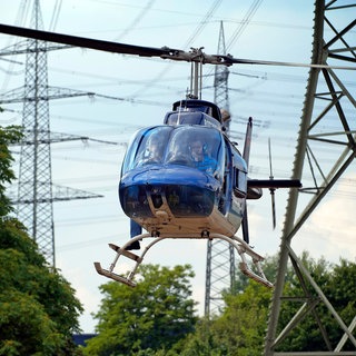 Von einem Hubschrauber aus kontrollieren Experten Stromleitungen. Dieses Foto wurde bei einem Flug über Nordrhein-Westfalen aufgenommen.