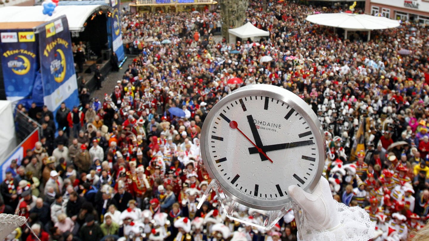 Ein Foto vom Schillerplatz in Mainz mit feiernden Menschen und einer Uhr für den Countdown am 11.11., der SWR überträgt die Veranstaltung